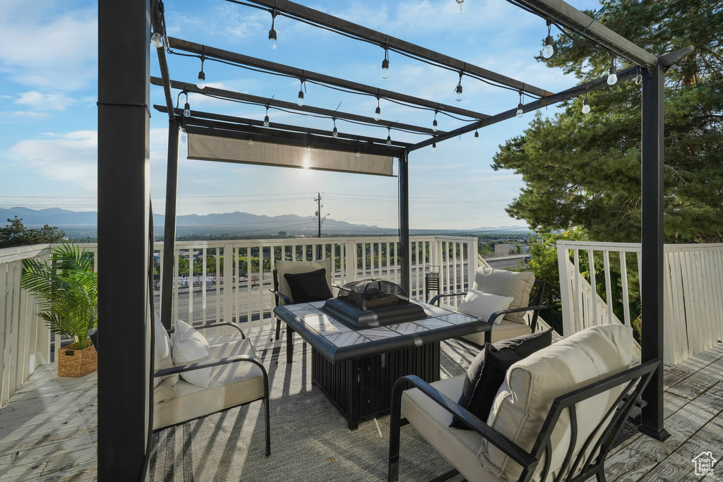 Wooden deck featuring a mountain view, a pergola, and an outdoor hangout area