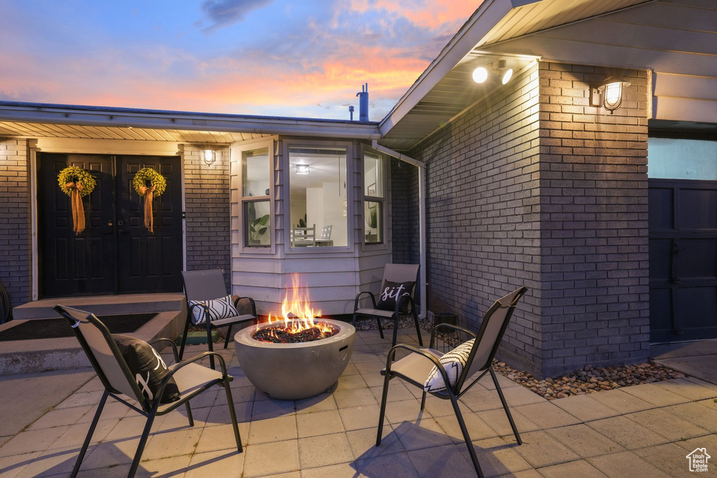 Patio terrace at dusk with a fire pit and a patio area