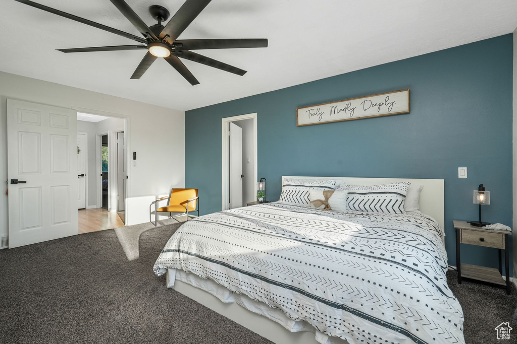 Carpeted bedroom featuring a ceiling fan