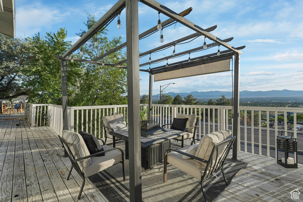 Deck featuring a pergola, a mountain view, and outdoor dining space