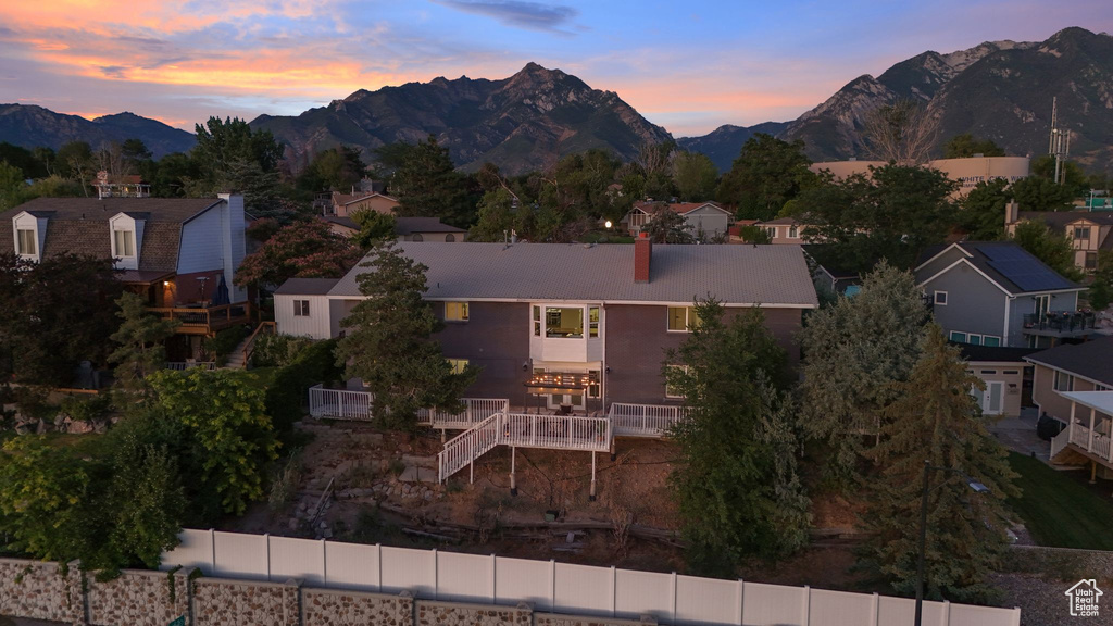 View of front of house with a mountain view, a chimney, and a residential view