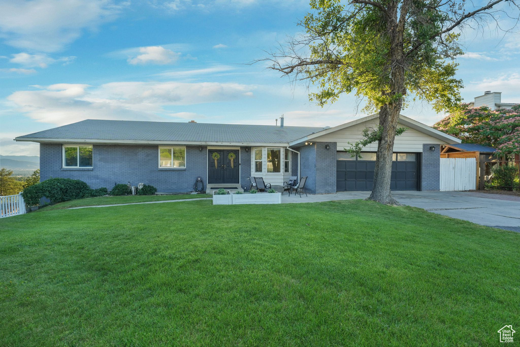 Single story home with brick siding, an attached garage, concrete driveway, and french doors