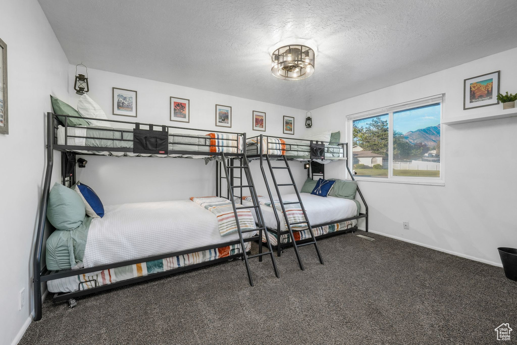 Bedroom featuring carpet floors and a textured ceiling