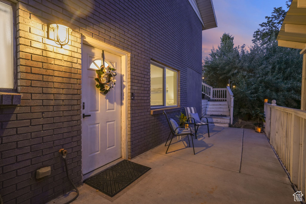 Exterior entry at dusk featuring brick siding