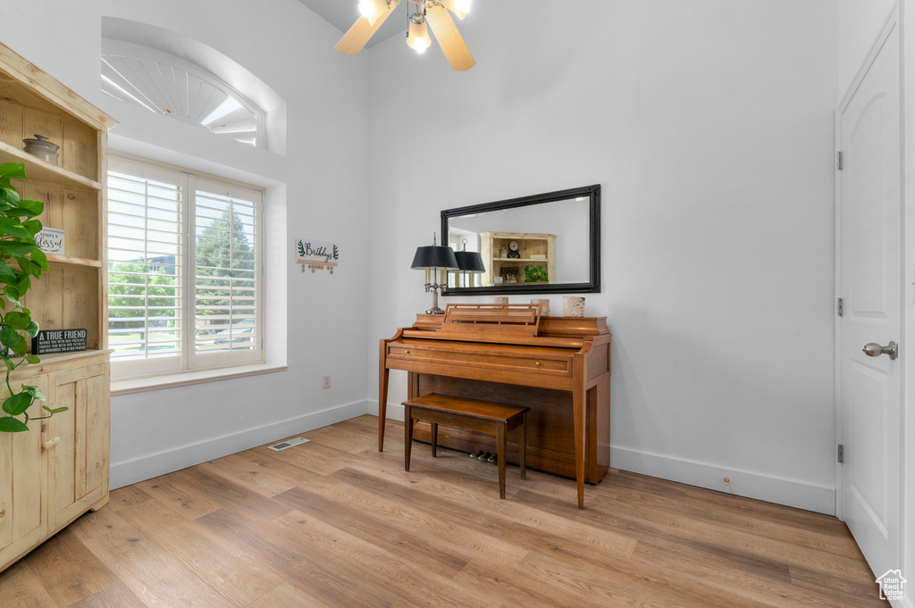 Living area with light wood finished floors and ceiling fan
