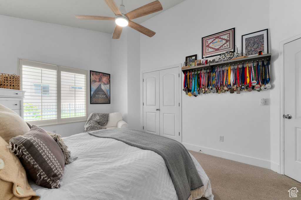 Bedroom with carpet floors, a closet, and a ceiling fan
