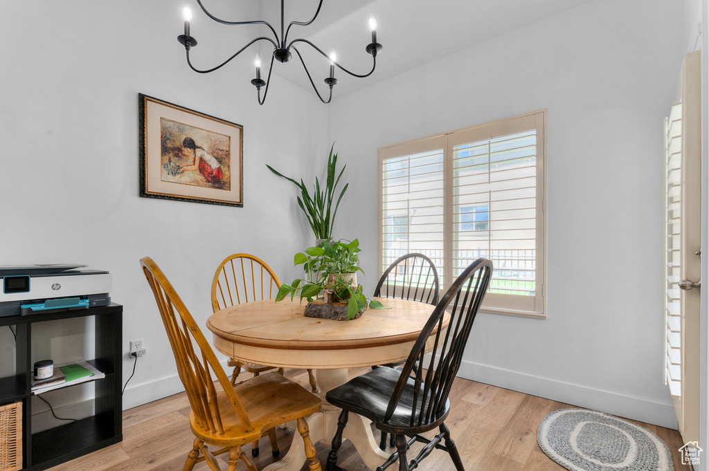 Dining room featuring healthy amount of natural light, a chandelier, and light wood finished floors