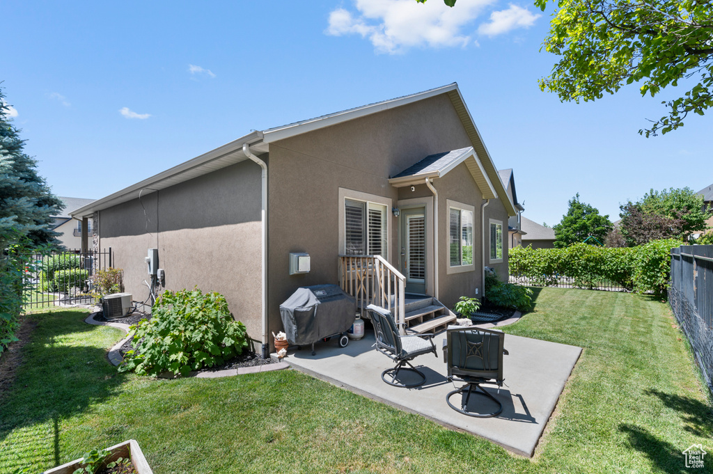 Rear view of property with stucco siding, a fenced backyard, and a patio area
