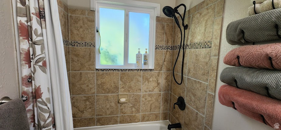 Bathroom with shower / bath combo with shower curtain and plenty of natural light
