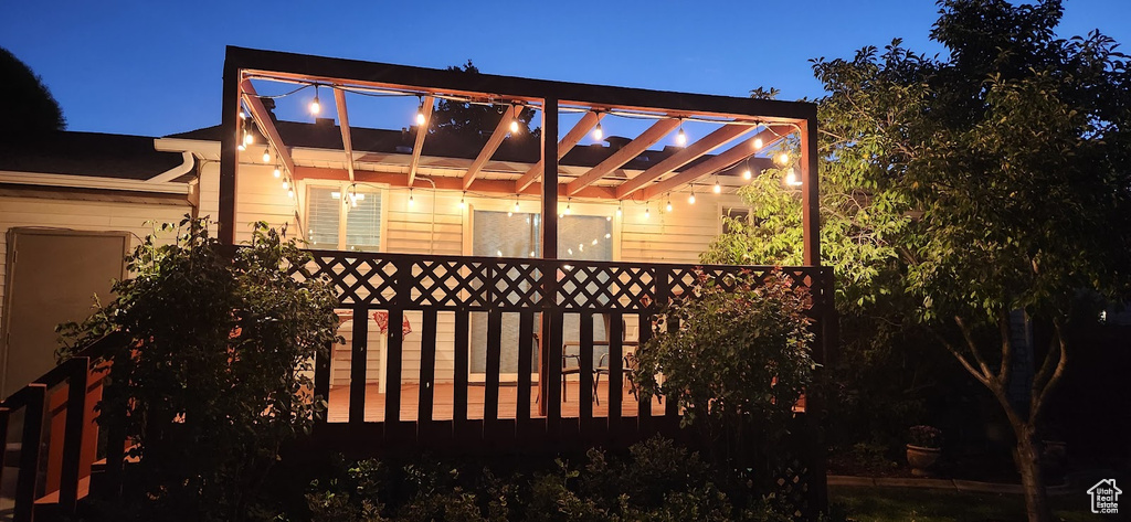 Patio at night with a wooden deck and a pergola