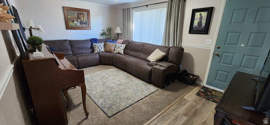 Living area with wood finished floors and crown molding