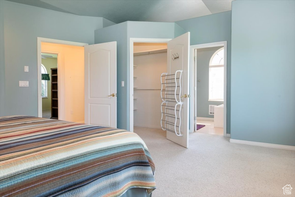 Carpeted bedroom featuring a spacious closet and ensuite bathroom
