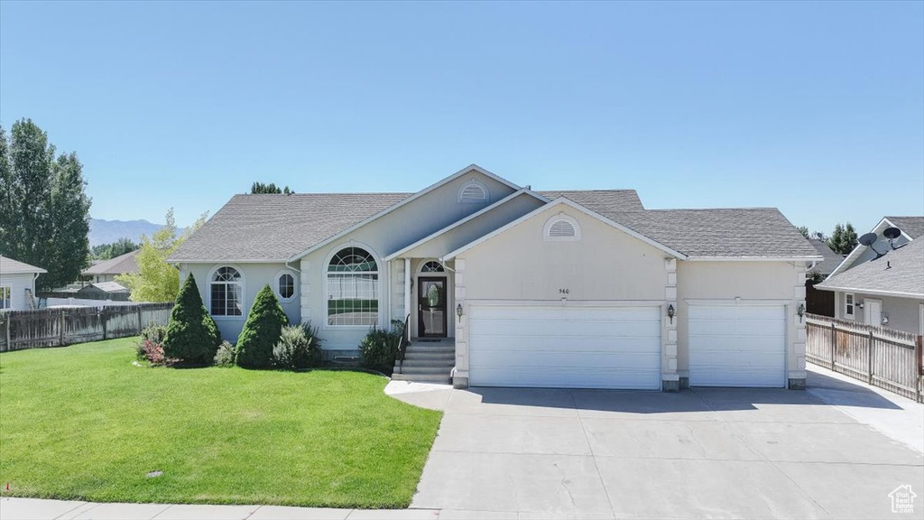 Single story home featuring a garage, roof with shingles, stucco siding, and driveway
