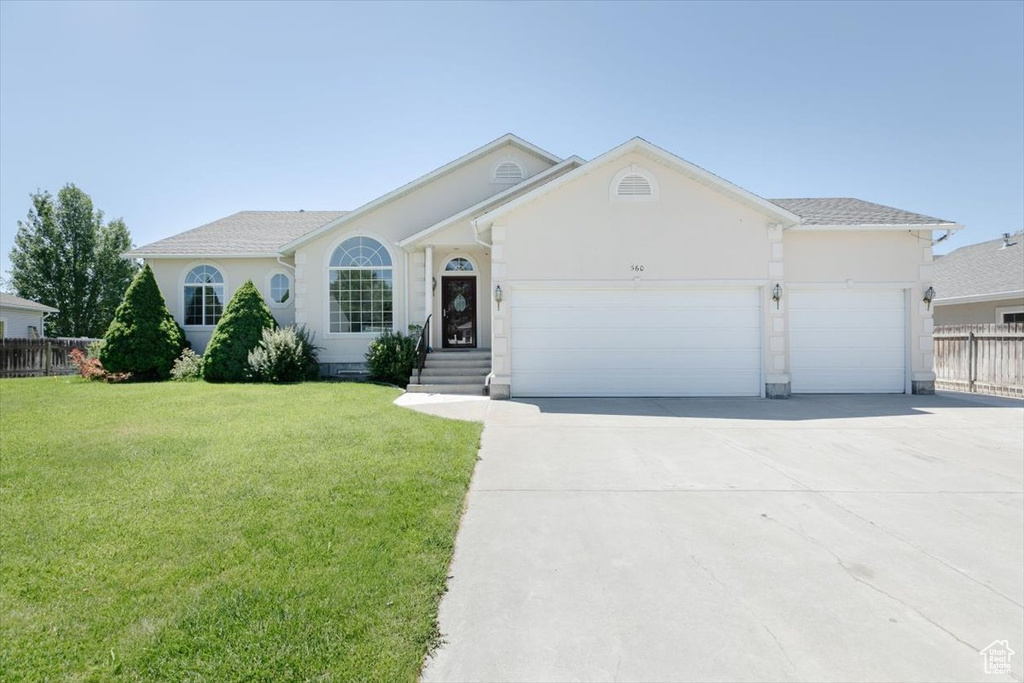 Single story home featuring stucco siding, a garage, and concrete driveway