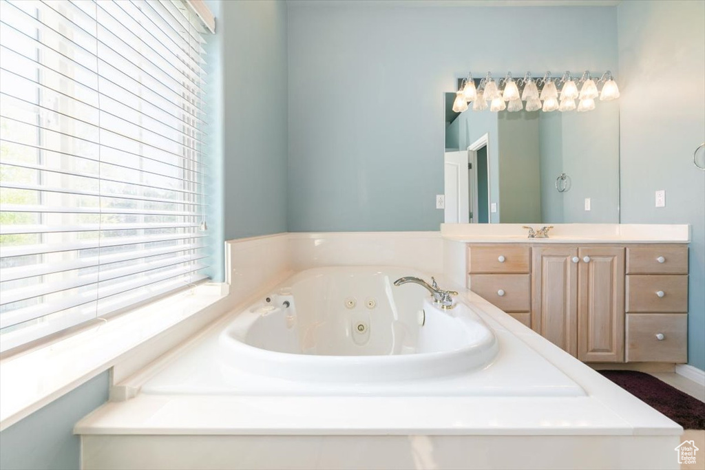 Bathroom with vanity and a tub with jets