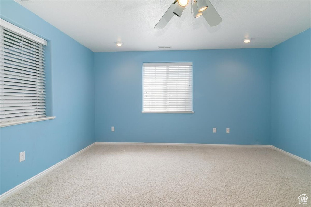 Spare room featuring a ceiling fan and carpet flooring