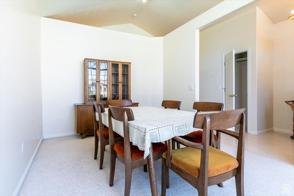 Dining space featuring light carpet and lofted ceiling