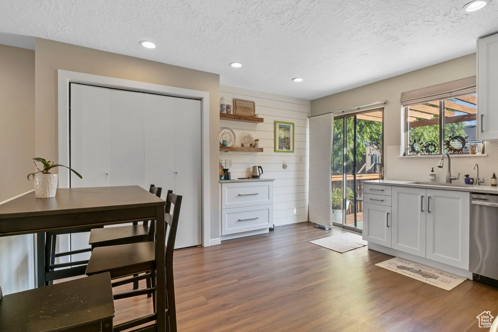 Dining space featuring dark wood-type flooring, a textured ceiling, and recessed lighting