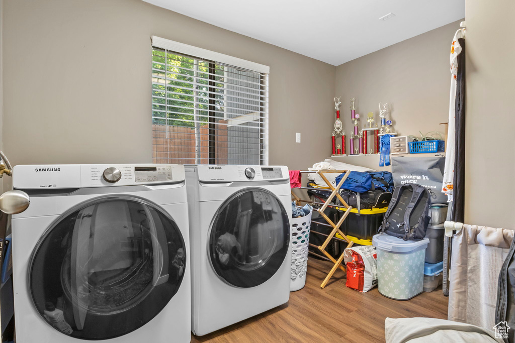 Washroom featuring wood finished floors and independent washer and dryer