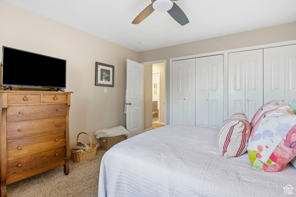 Bedroom with carpet floors, multiple closets, and a ceiling fan