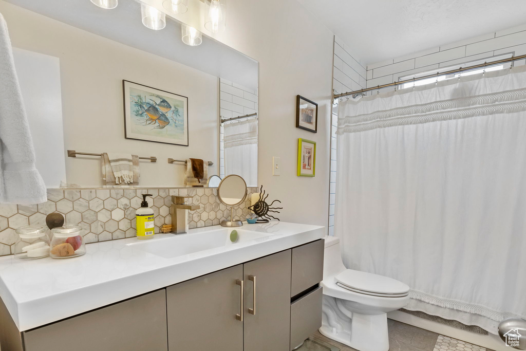 Full bathroom with decorative backsplash, vanity, tile patterned floors, and a shower with curtain
