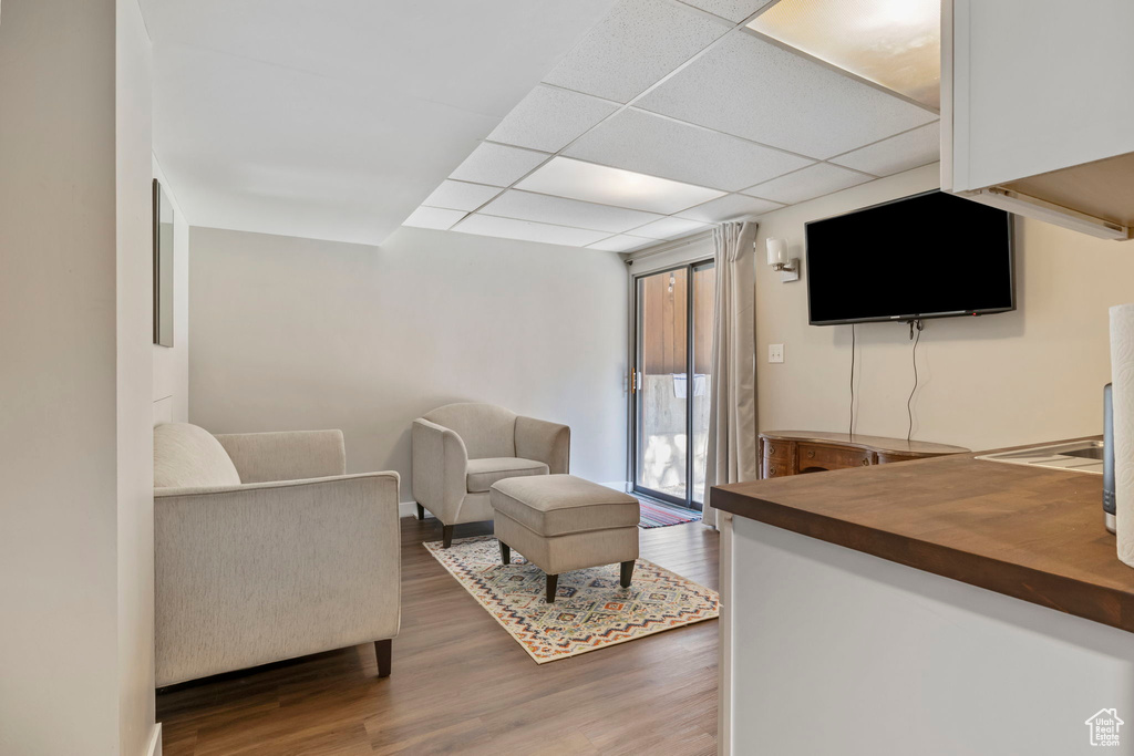 Living area with wood finished floors and a paneled ceiling