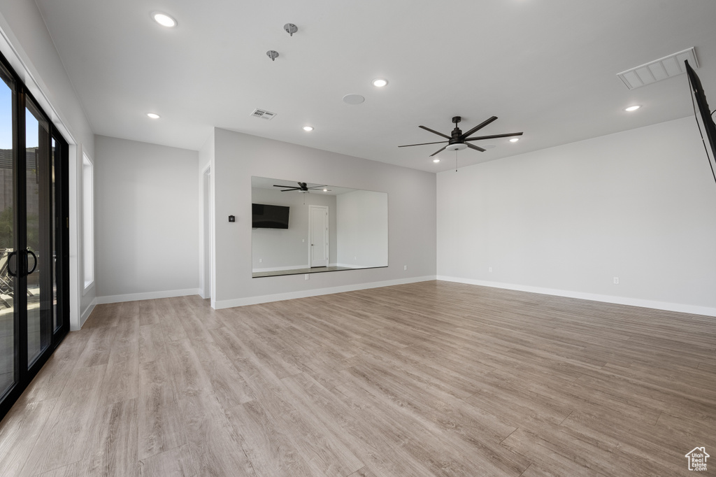 Unfurnished living room featuring a ceiling fan, light wood finished floors, and recessed lighting