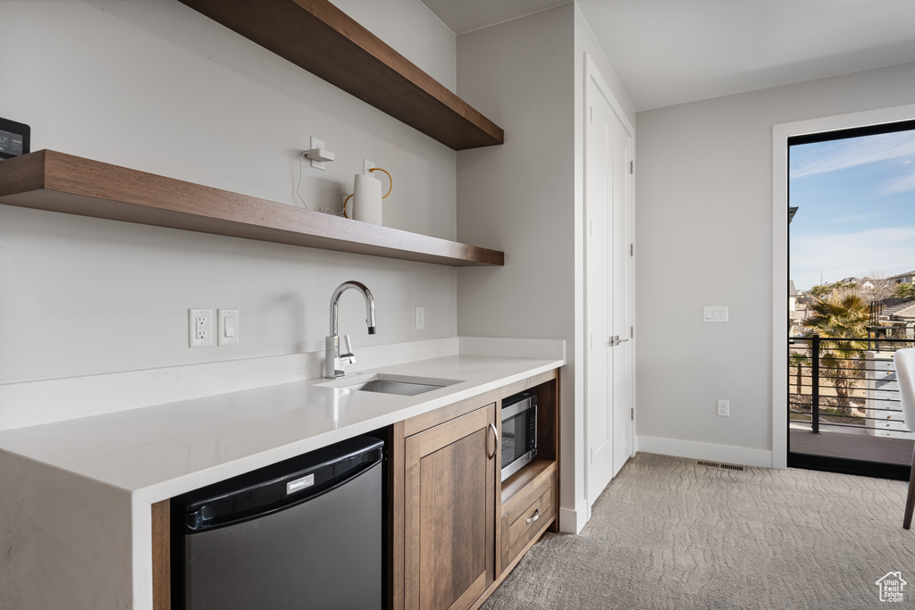 Kitchen with open shelves, appliances with stainless steel finishes, light carpet, and light countertops