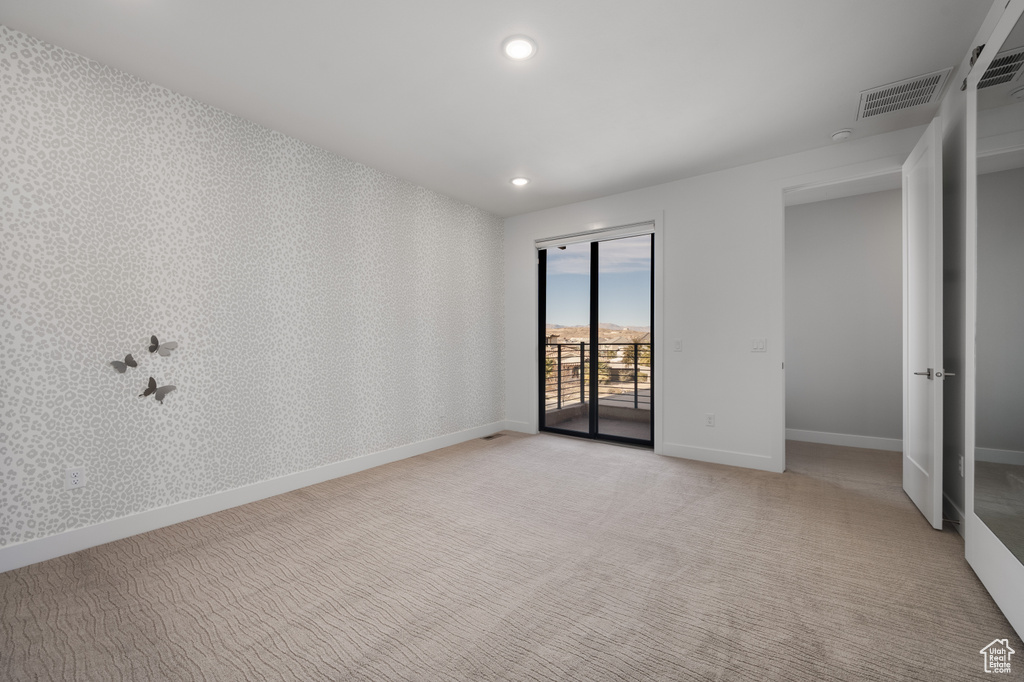 Empty room featuring light colored carpet and recessed lighting