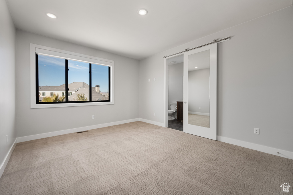Unfurnished bedroom with carpet floors, recessed lighting, and ensuite bath