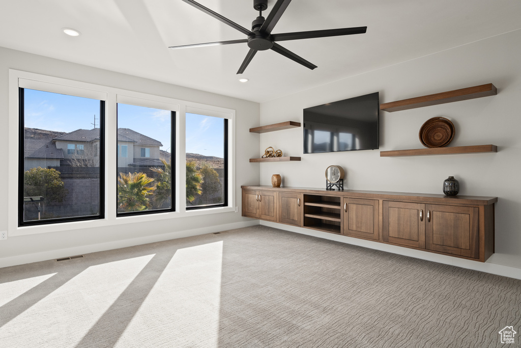 Living area with light colored carpet, ceiling fan, and recessed lighting