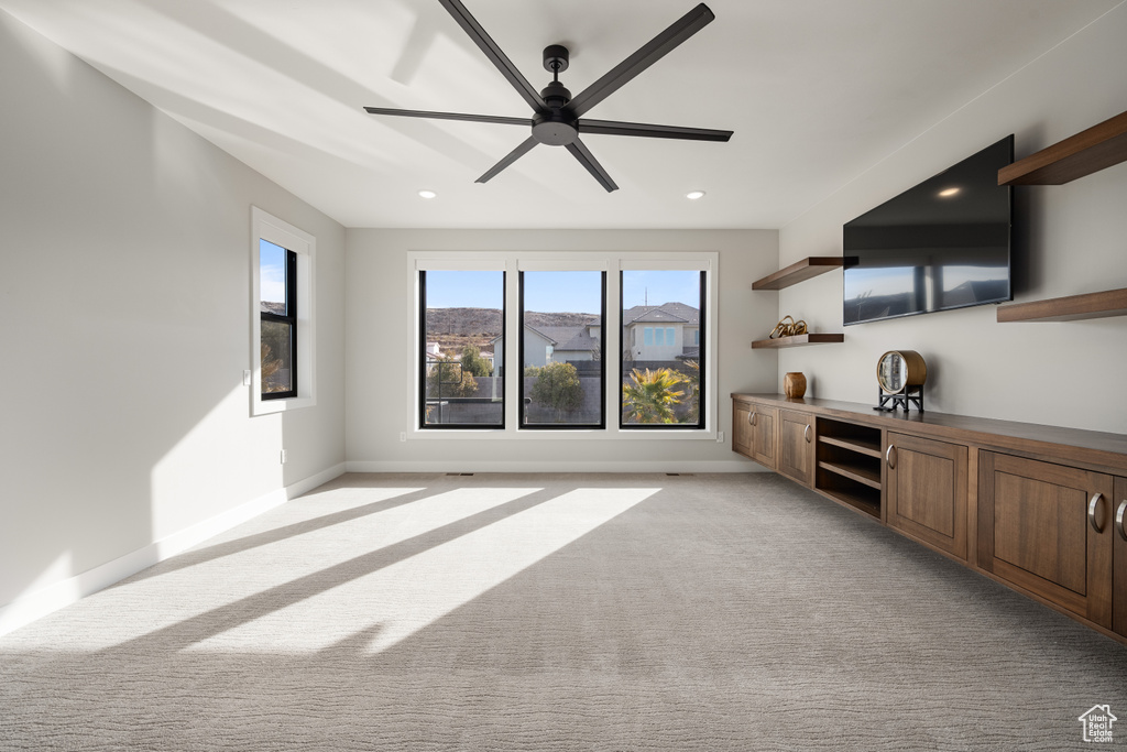 Unfurnished living room featuring a ceiling fan, light colored carpet, and recessed lighting