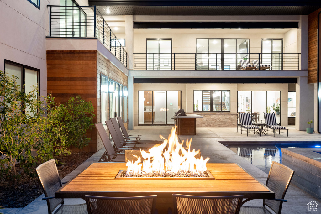 Rear view of property with a fire pit, a patio area, and an outdoor pool