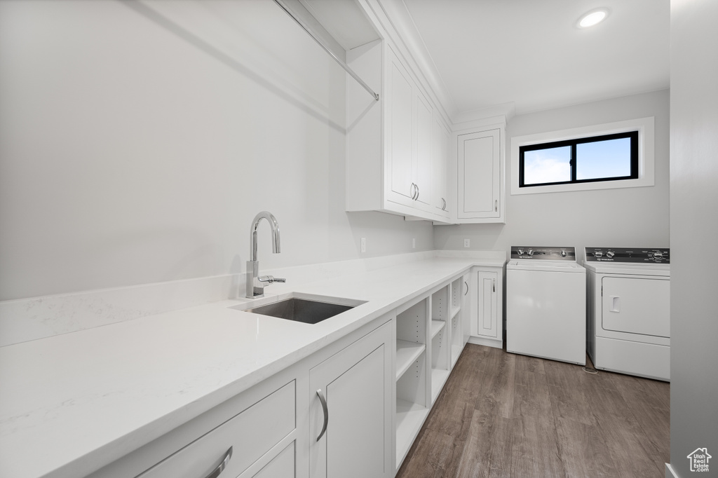 Laundry room featuring cabinet space, washer and dryer, wood finished floors, and recessed lighting