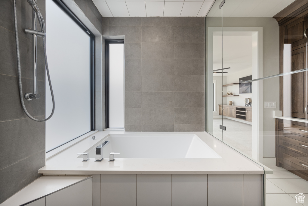 Bathroom featuring a tub, tile patterned flooring, and a shower
