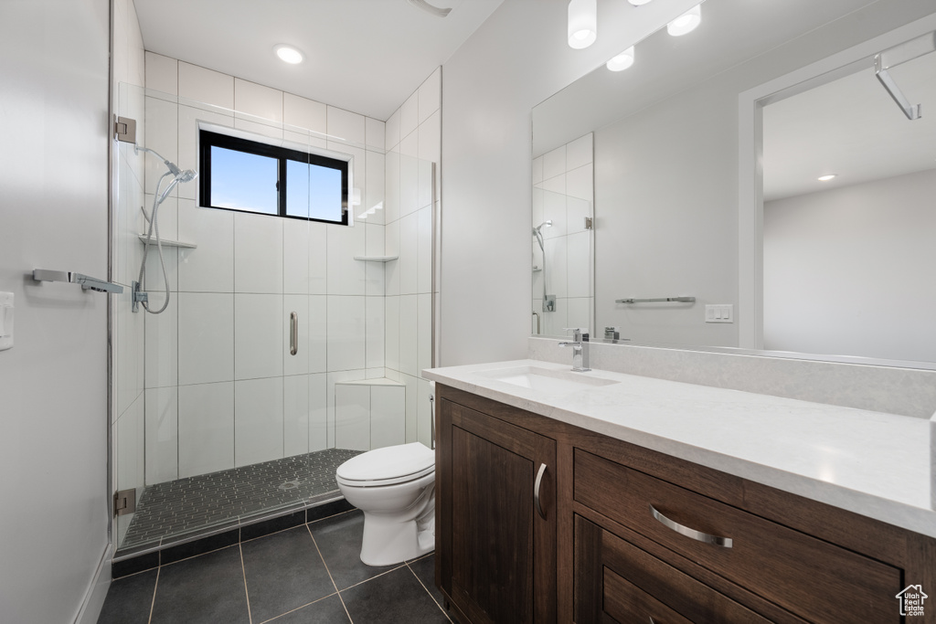 Full bath with tile patterned floors, a shower stall, and vanity