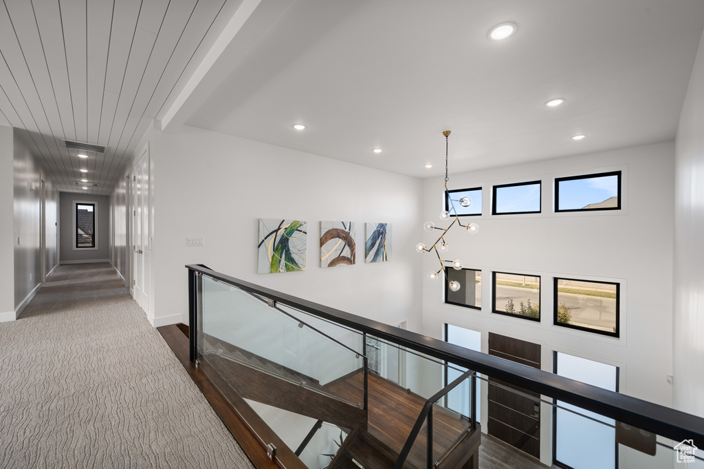 Hall with an upstairs landing, healthy amount of natural light, and recessed lighting