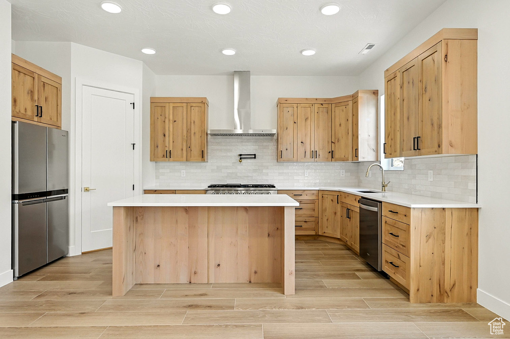 Kitchen featuring stainless steel appliances, a center island, light wood-style floors, light brown cabinetry, and recessed lighting