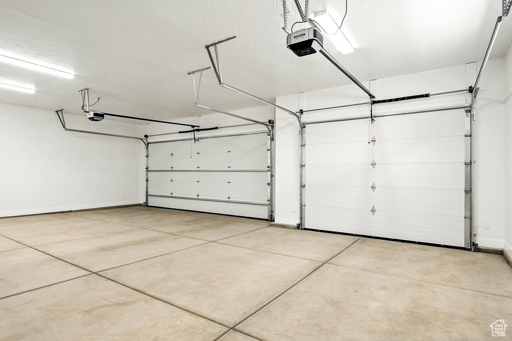 Garage with baseboards and a garage door opener