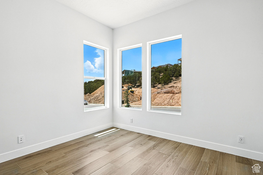 Unfurnished room featuring wood finished floors and baseboards