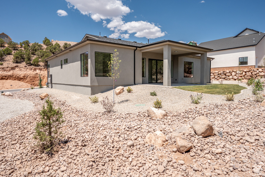 View of front of property with stucco siding and a patio