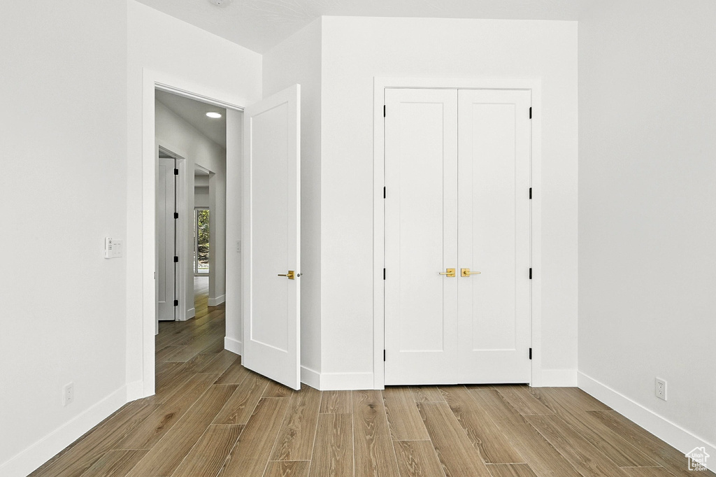 Unfurnished bedroom featuring light wood finished floors, recessed lighting, and a closet