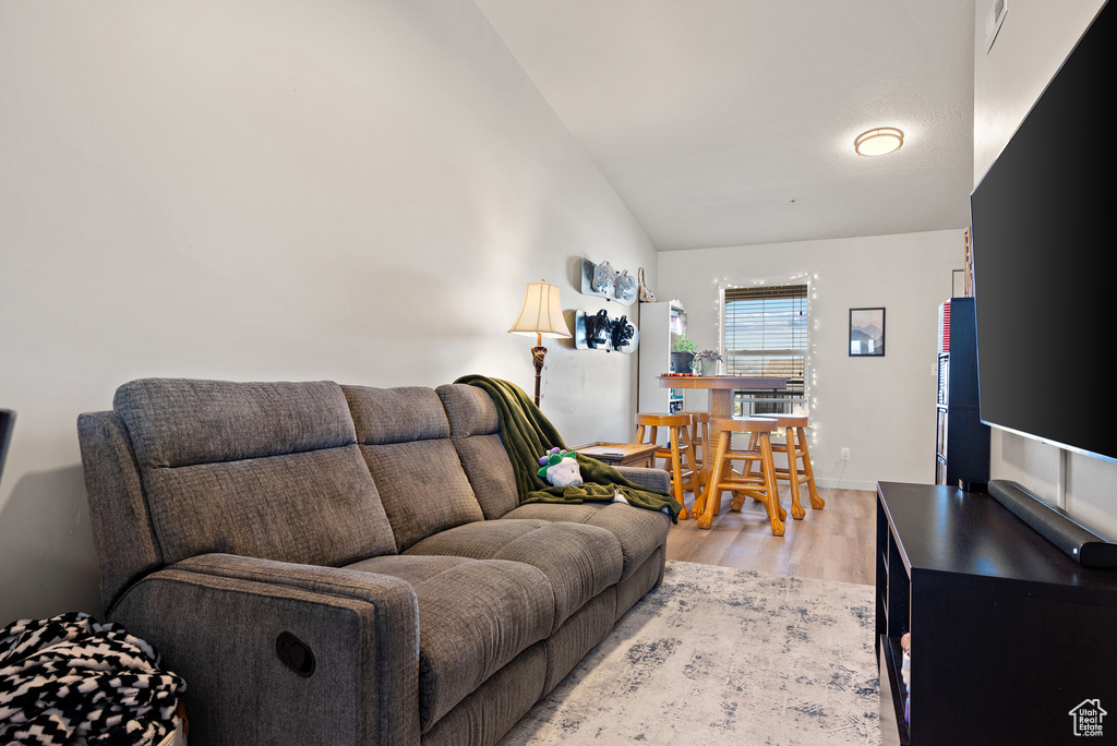 Living area with light wood-type flooring and lofted ceiling
