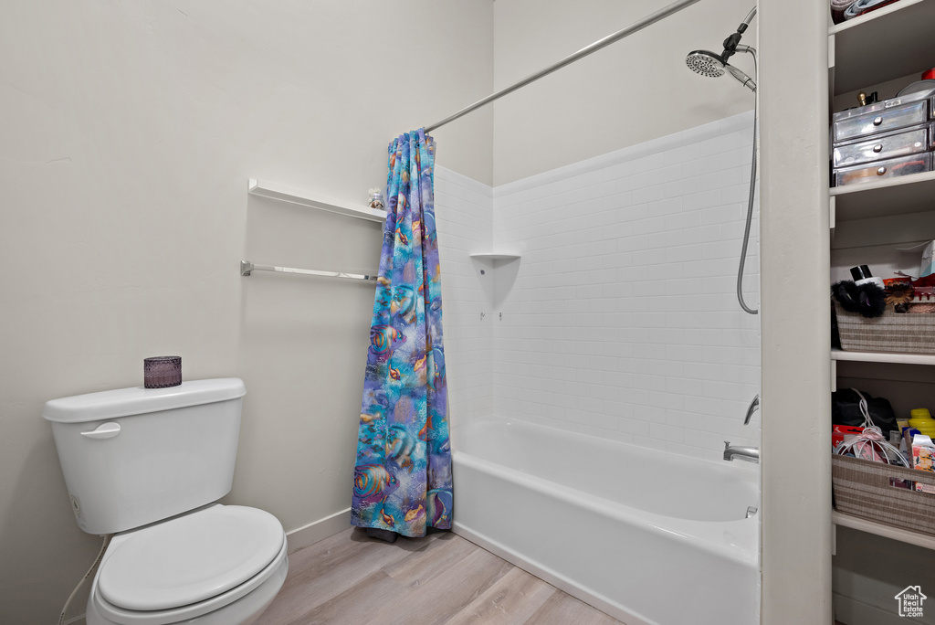 Full bath featuring wood finished floors and shower / tub combo