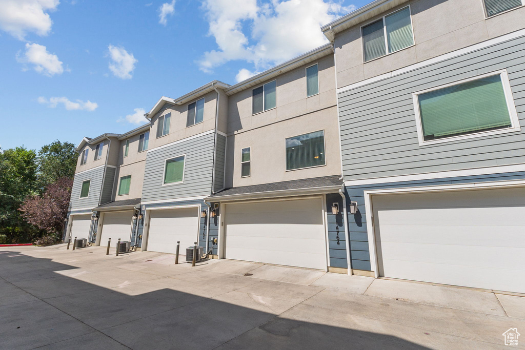 View of front of home with an attached garage and stucco siding