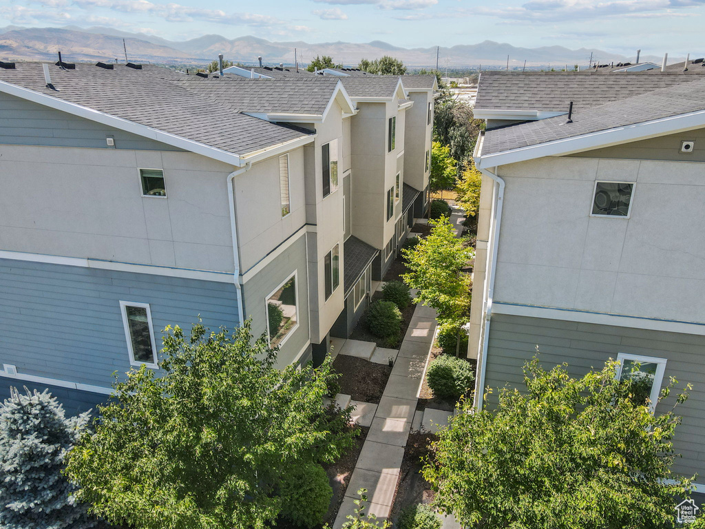 View of side of home featuring a mountain view and a shingled roof