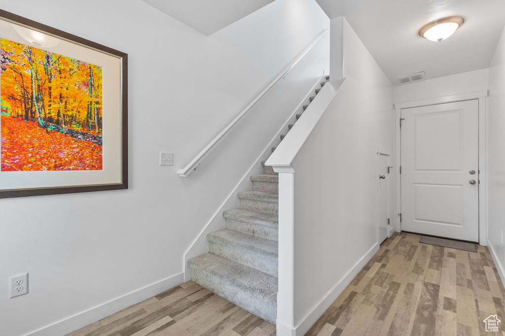 Staircase with wood finished floors and baseboards
