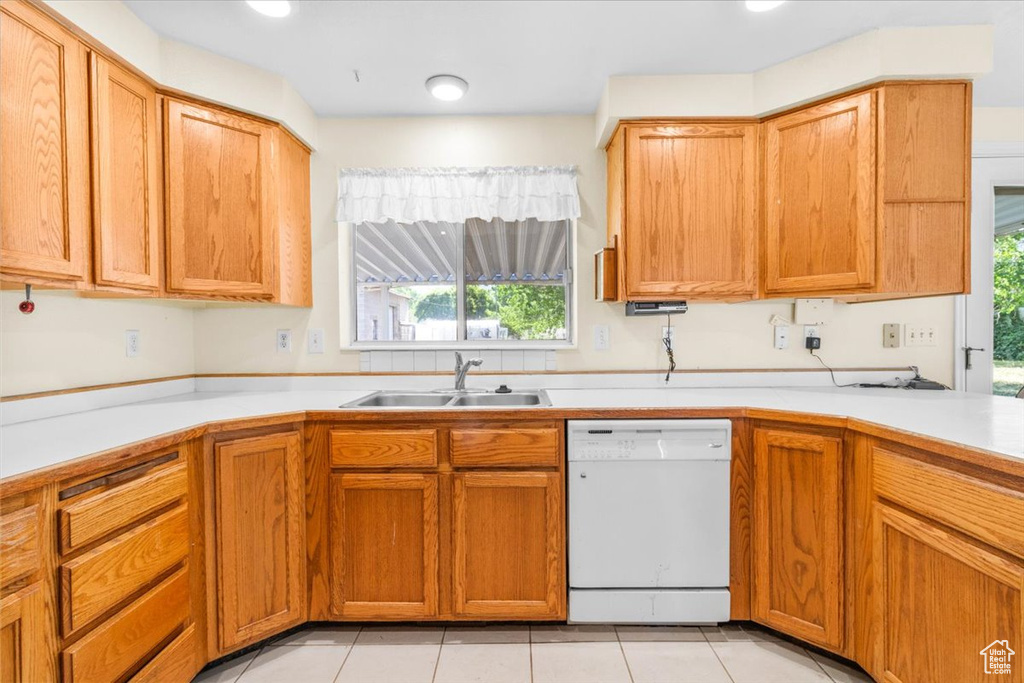 Kitchen with dishwasher, healthy amount of natural light, light countertops, and light tile patterned floors