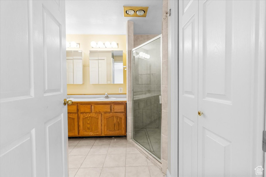 Bathroom with vanity, tile patterned floors, a stall shower, and a closet