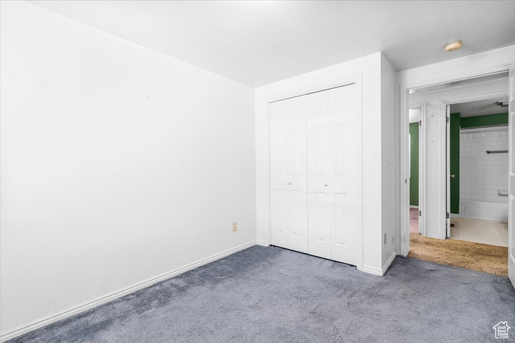 Unfurnished bedroom featuring carpet and a closet